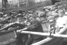 209: l-r in boat, Brian Hennessey, unidentified, Ray Carroll, John Carroll, Len Ryan;  John Whelan in background. At Dunphy's beach. Bill Webber's house is in the background. (1950)  - Brian (visitor) son of John Hennessey &amp;amp; Anastasia McCarthy; Ray and John sons of Michael  Carroll &amp;amp; Josie Barry; Len son of Francis Ryan &amp;amp; Eliz Barry; John son of (?)